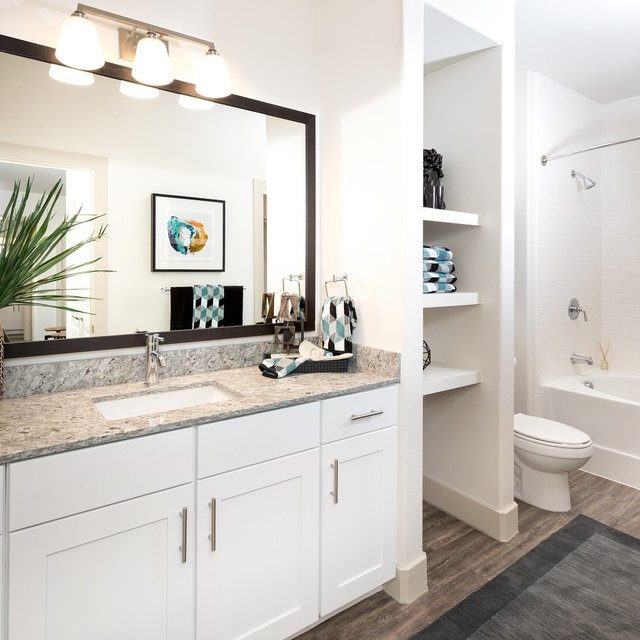 Spacious Bathrooms with Framed Mirrors, Granite Countertops, Wood Style Flooring, and Garden Tubs*